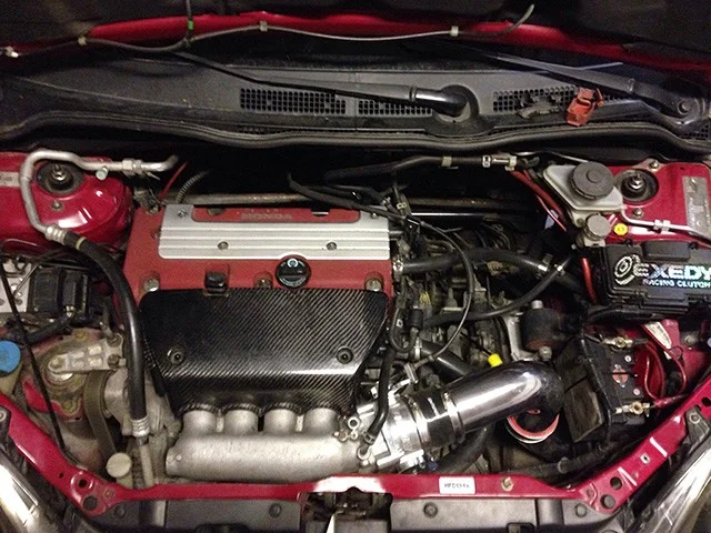 Motorrum i en röd Honda Civic Type R EP3 med K20A2, kolfiberkåpa och grovt spjällhus