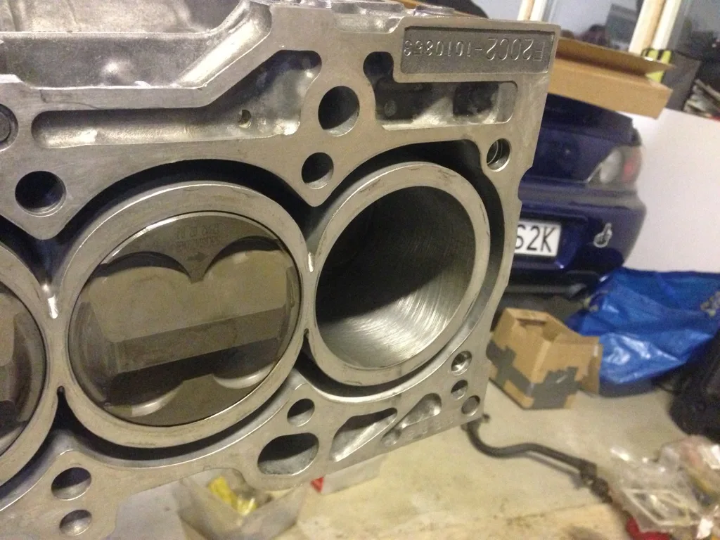 Motorblock till Honda F20C med cylinderfoder och kolvar, S2000 i bakgrunden